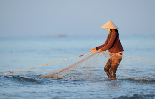 Photo of woman fishing in Mui–Ne, Vietnam by Ron Veto