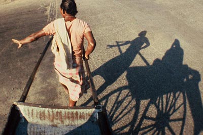 Photo of rickshaw and rickshaw shadow on street in Calcutta, India by Ron Veto