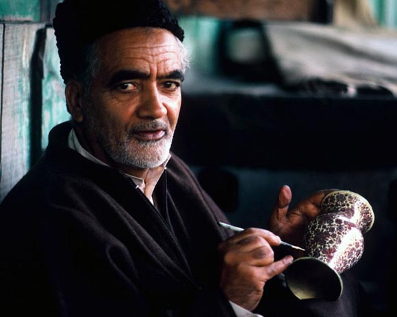 Photo of artist painting pot in Kashmir, India by Ron Veto /></div>
<p style=